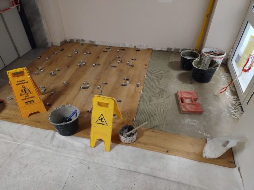 Fliesenverlegung im Büroflur mit großen Bodenfliesen in Holzoptik