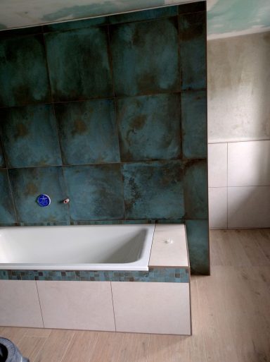 Badezimmer mit grünen Wandfliesen und Bodenfliesen in Marmoroptik