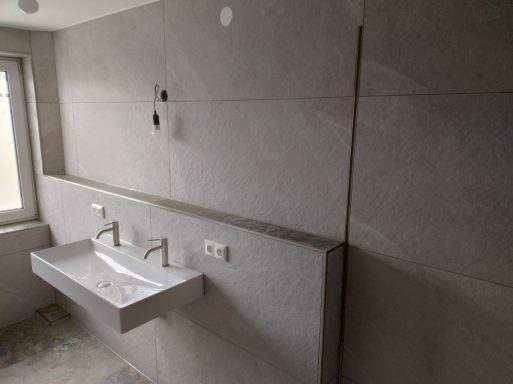 Waschtischbereich im neuen Badezimmer mit Fliesen in Marmoroptik