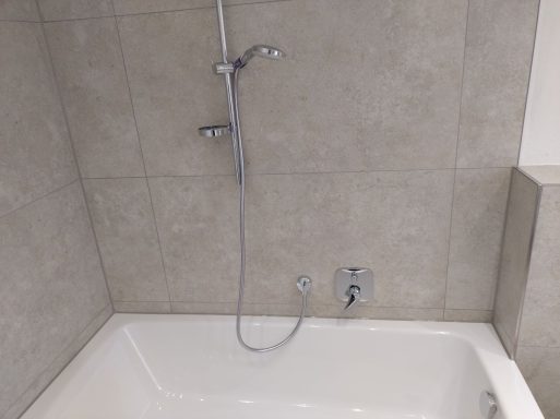 Badewannenbereich mit neuen Silikonfugen und Fliesen in Marmoroptik