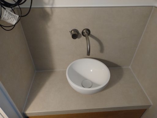 Kleines Badezimmer mit Waschbecken und WC – Großformatfliesen und neue Silikonfugen