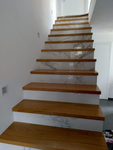 Treppe mit Holzstufen und Setzstufen aus Fliesen in Marmoroptik