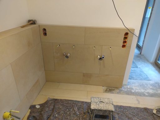 Waschtischbereich mit weißen Wänden in Q4-Spachtelqualität und Fliesen in Sandsteinoptik