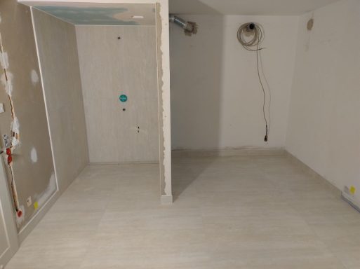 Badezimmer mit Dusche und Bodenfläche für Sauna – Fliesen in gleicher heller Marmoroptik