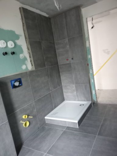 Verlegung von modernen Betonoptik-Fliesen im Bad – ideal für minimalistisches Interieur.