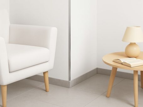 Q4-Spachtelung in heller Wohnatmosphäre – modern, ruhig, elegant Heller Raum mit glatter Q4-Wand, weißem Designersessel, Beistelltisch und Stehlampe – perfekte Basis für stilvolle Inneneinrichtung.