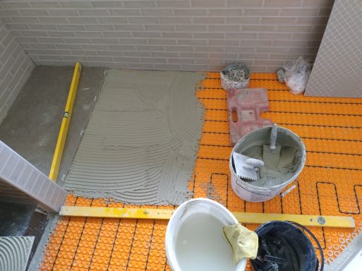 Badezimmer mit kleinformatigen Wandfliesen im Ziegelformat und Großformatfliesen auf dem Boden mit elektrischer Fußbodenheizung